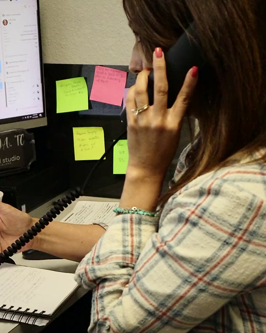 A front desk team member on the phone with a patient at The Dental Studio of Midland