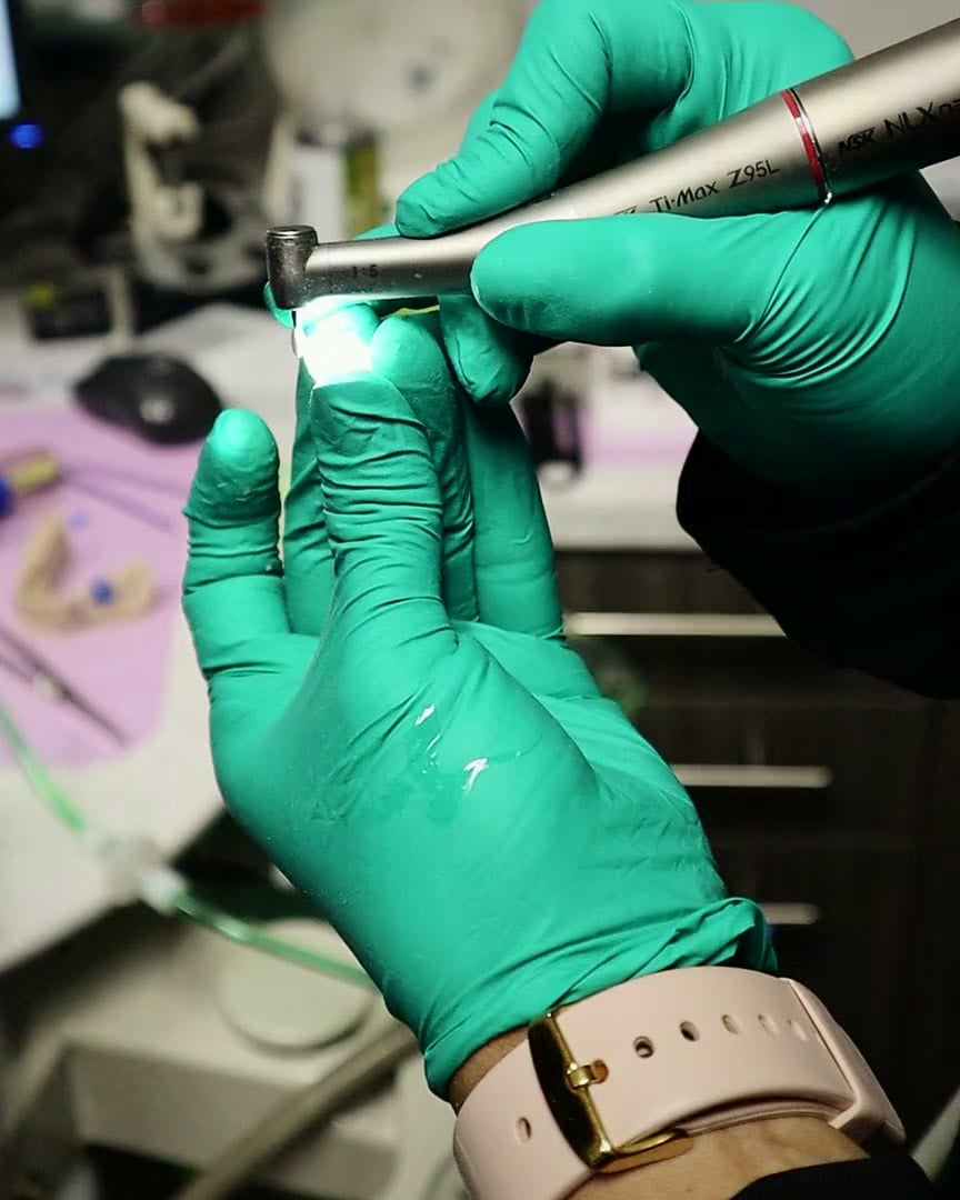 A clinician checking the light on a dental handpiece at The Dental Studio of Midland