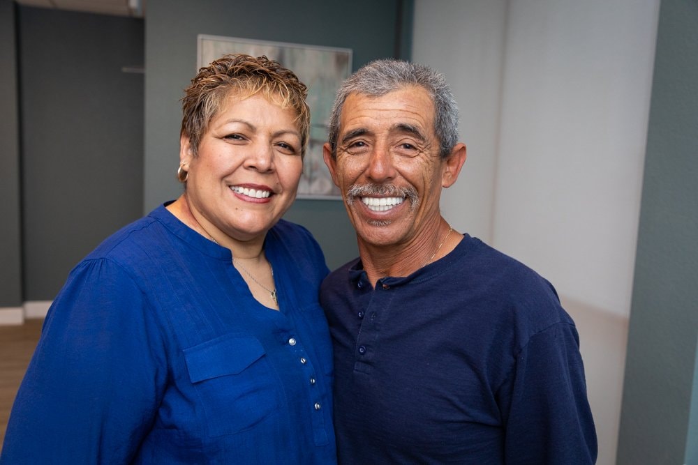A smiling couple in the Dental Studio of Midland lobby after treatment